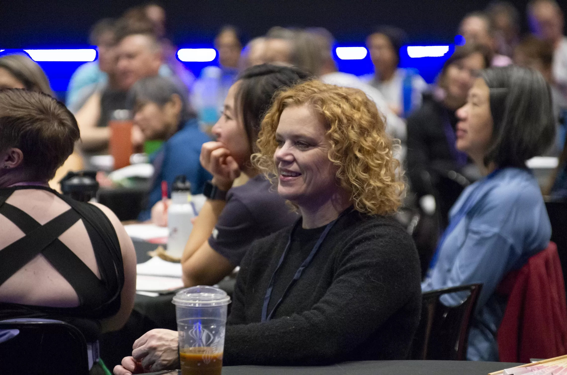 A fitness instructor smiles while at a conference