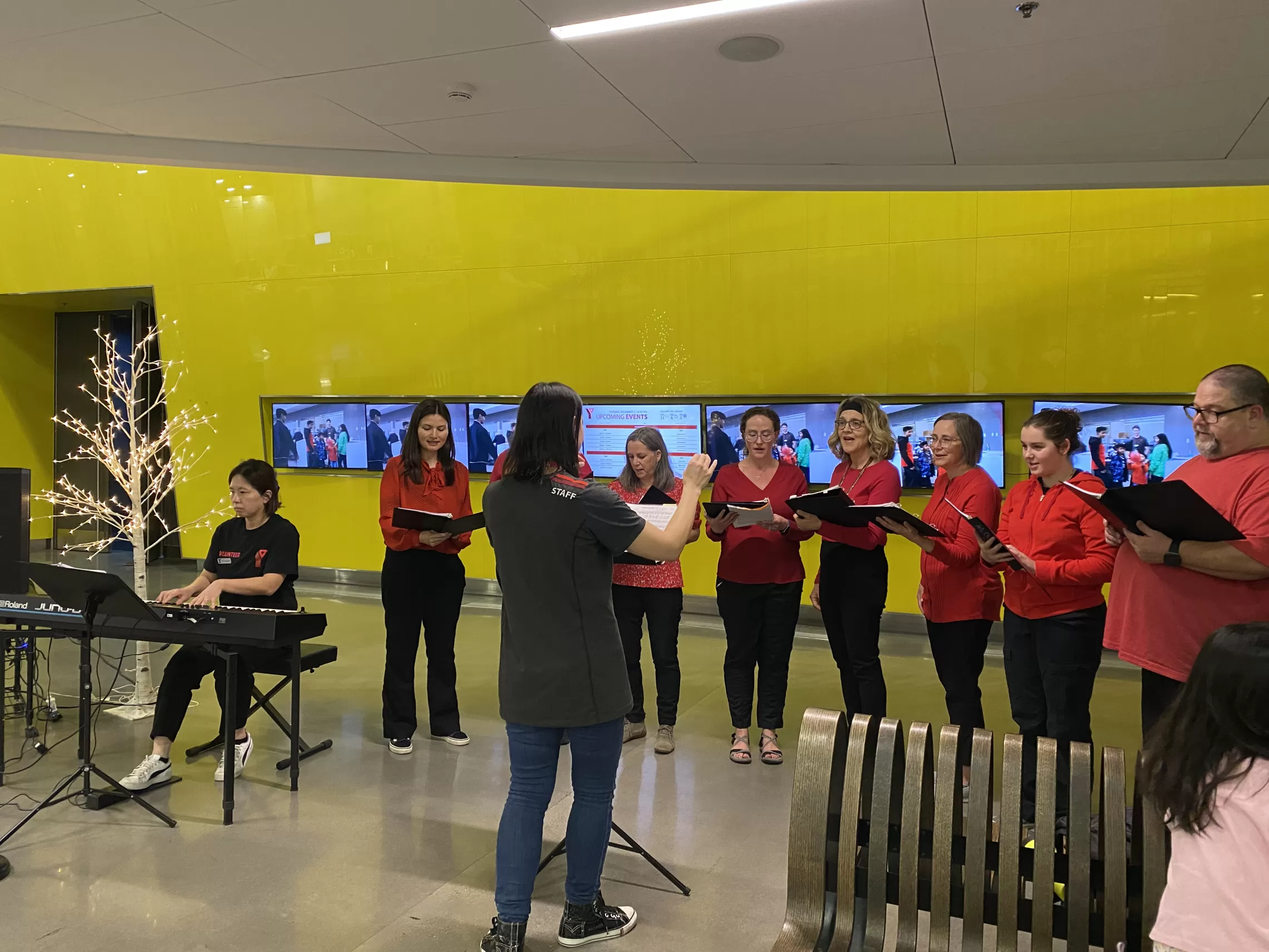 A group of choir singers in the lobby of a YMCA