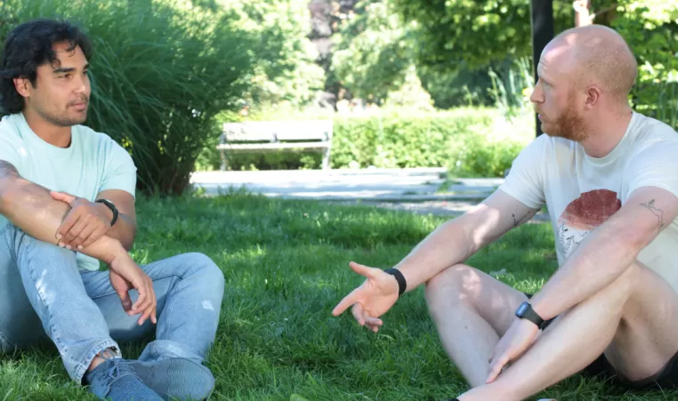 Men sitting on lawn chatting